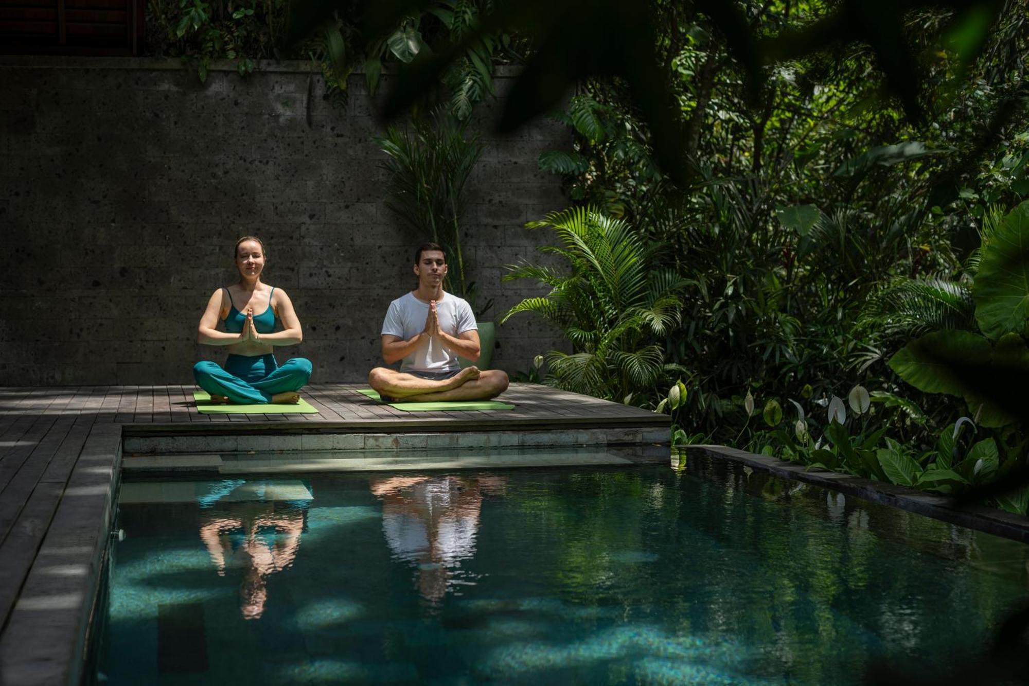 Hotel Adiwana Suweta Ubud Exterior foto A couple practicing yoga at the Bvlgari Spa